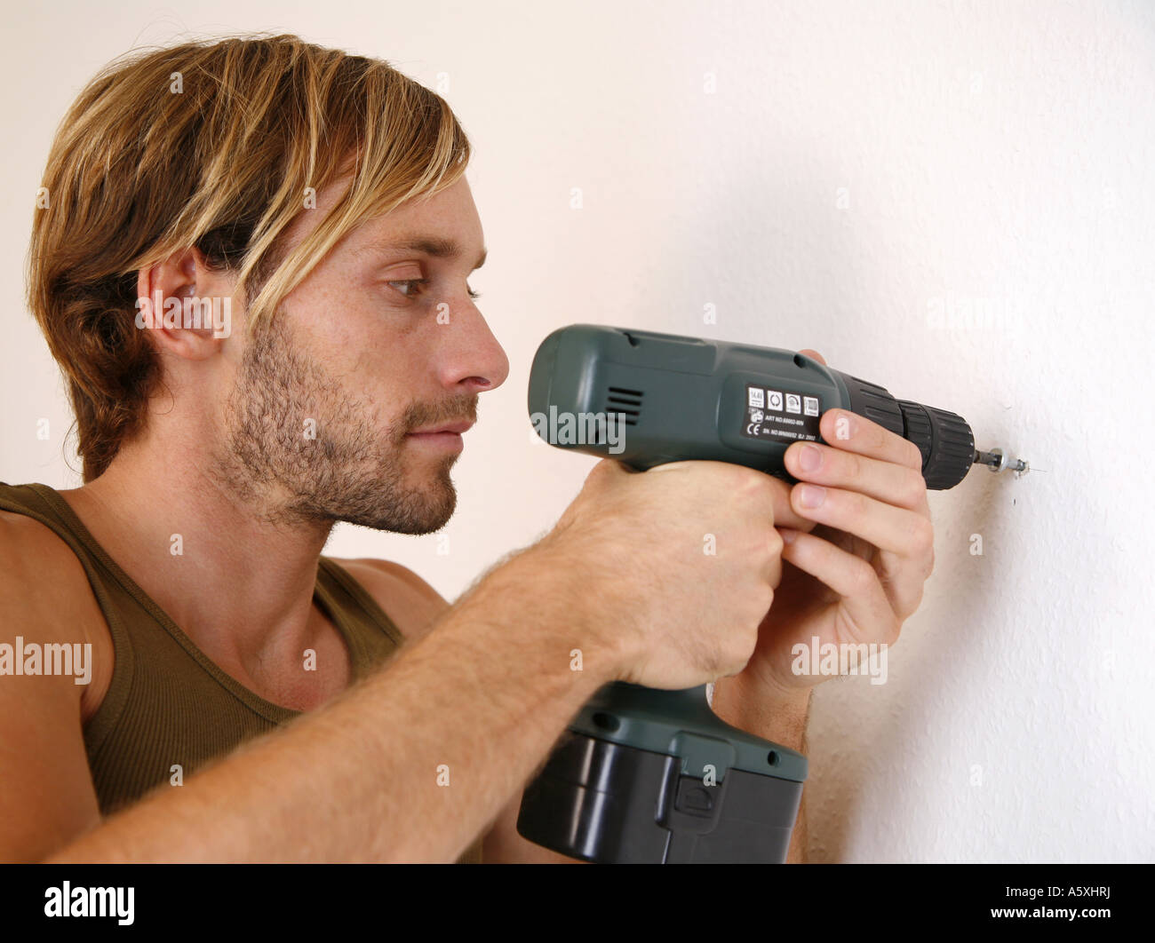 Young man screwing screw in wall portrait close up Stock Photo Alamy