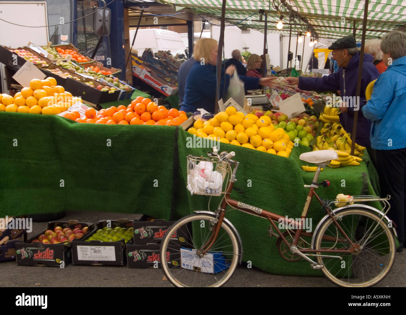 People browsing a fruit and vegetable stall at the Saturday Market in