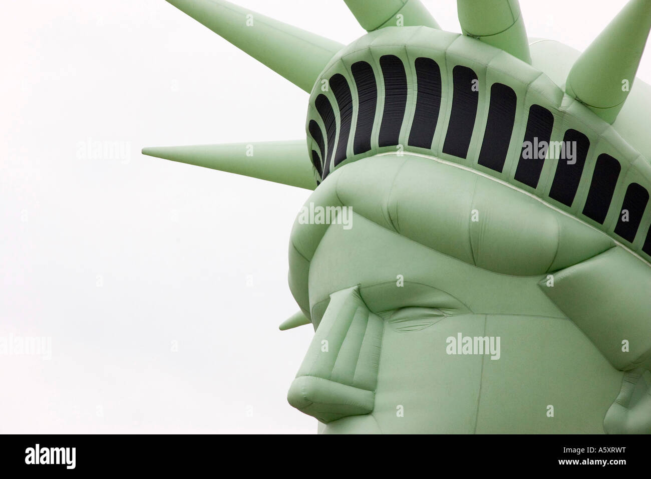 inflatable statue of liberty head against a white sky background Stock Photo