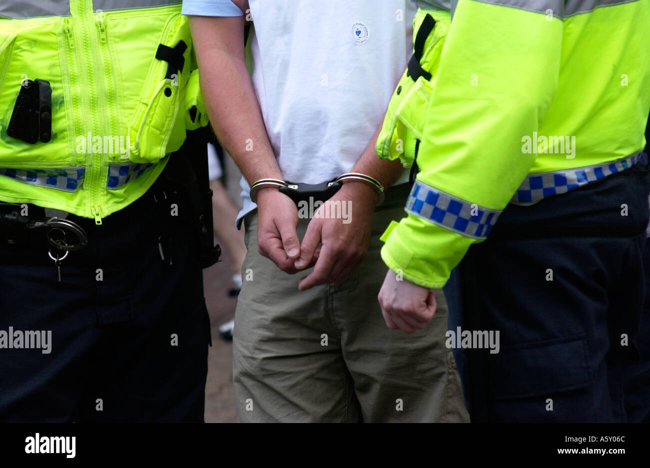 Officers handcuff and detain man on suspicion of selling forged tickets for FA Cup Final in Cardiff City Centre South Wales UK Stock Photo