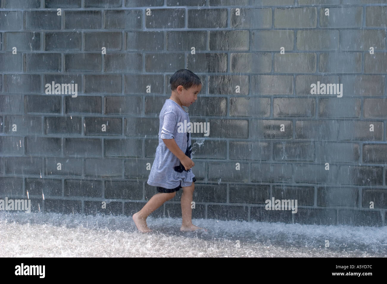 Four year old boy playing in Crown Fountain Millennium Park Chicago Illinois USA Stock Photo