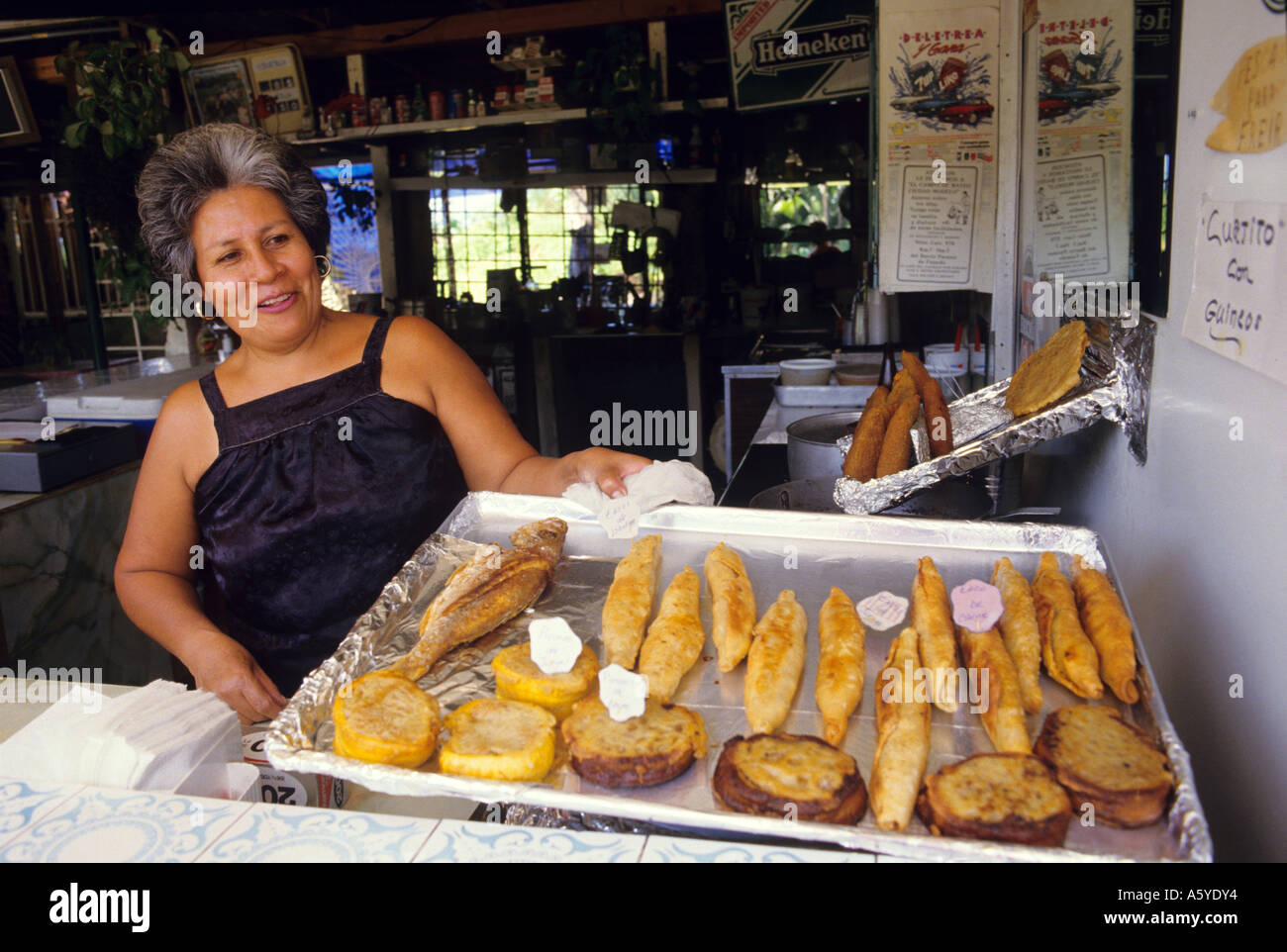A woman sells fried Puerto Rican food at a sidewalk cafe in Puerto Rico. Stock Photo