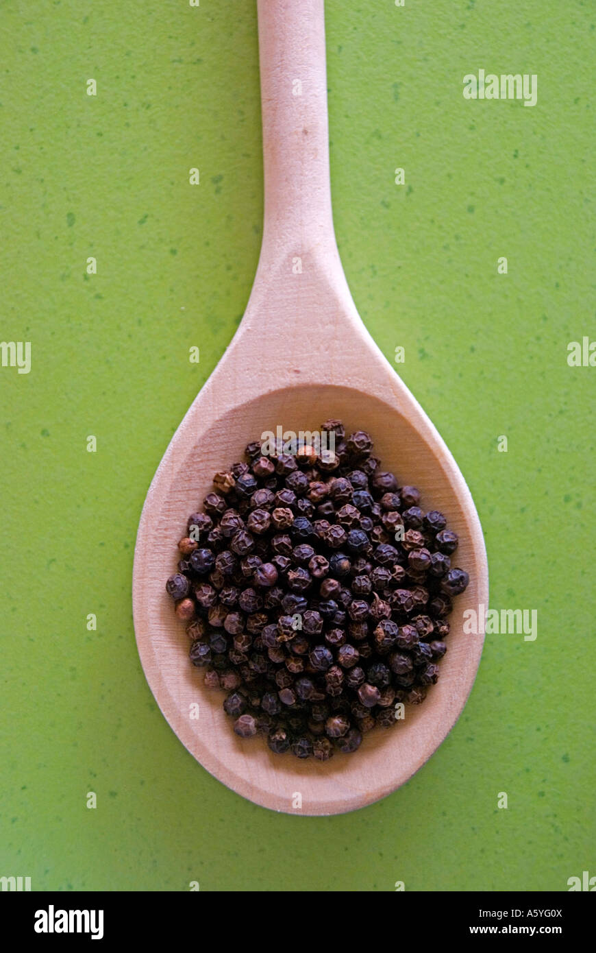 black pepper in a wooden spoon Stock Photo