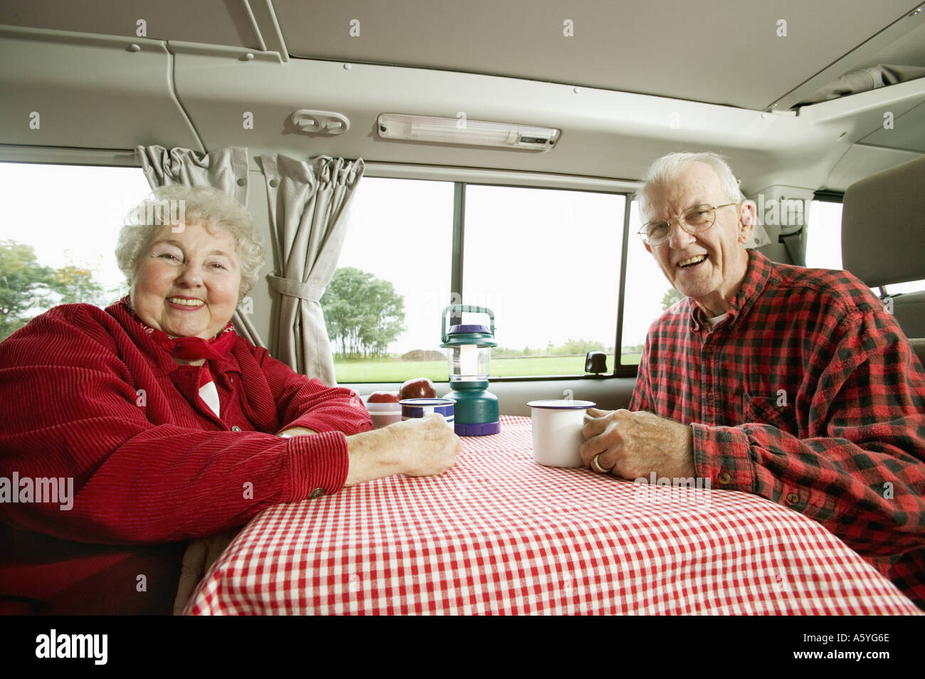 Senior couple sitting together in their van Stock Photo