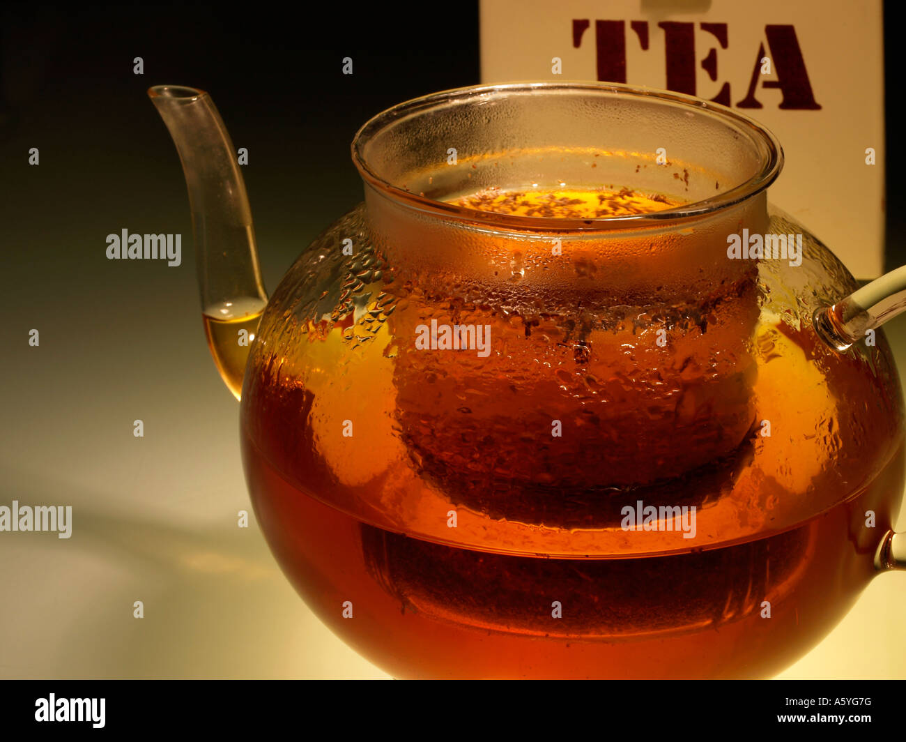 tea in a glasware teapot and a tea caddy Stock Photo