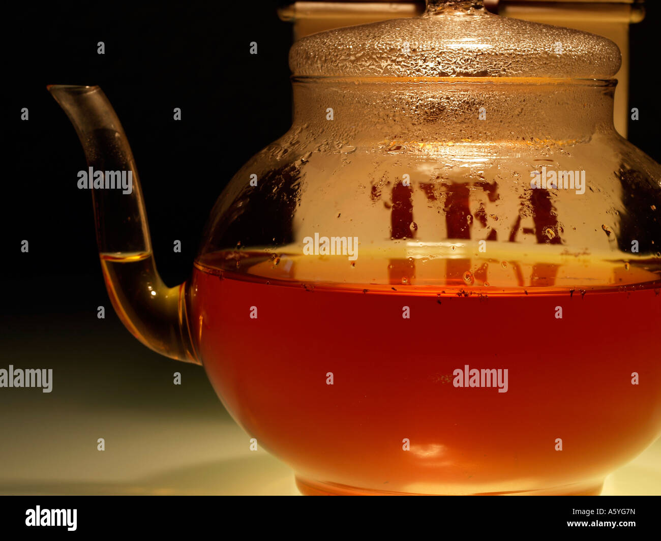 tea in a glasware teapot and a tea caddy Stock Photo