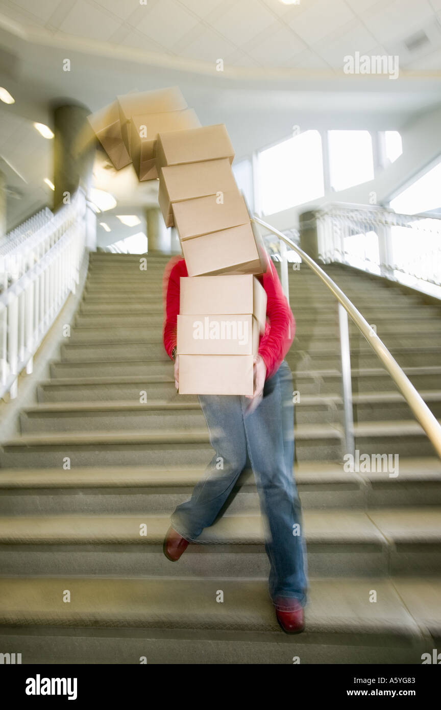 Woman carrying boxes downstairs Stock Photo Alamy