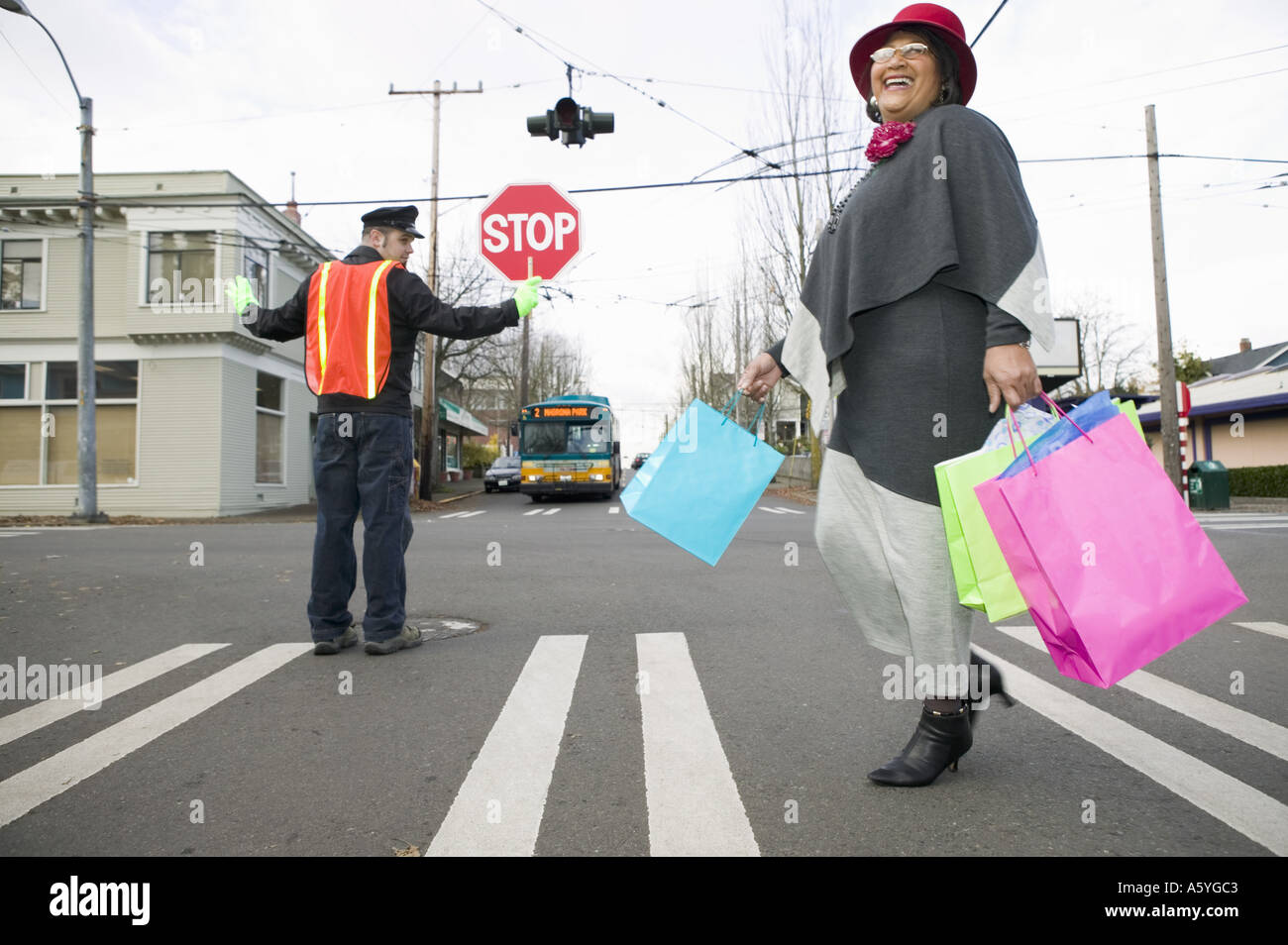 Woman with shopping bags crossing street Stock Photo