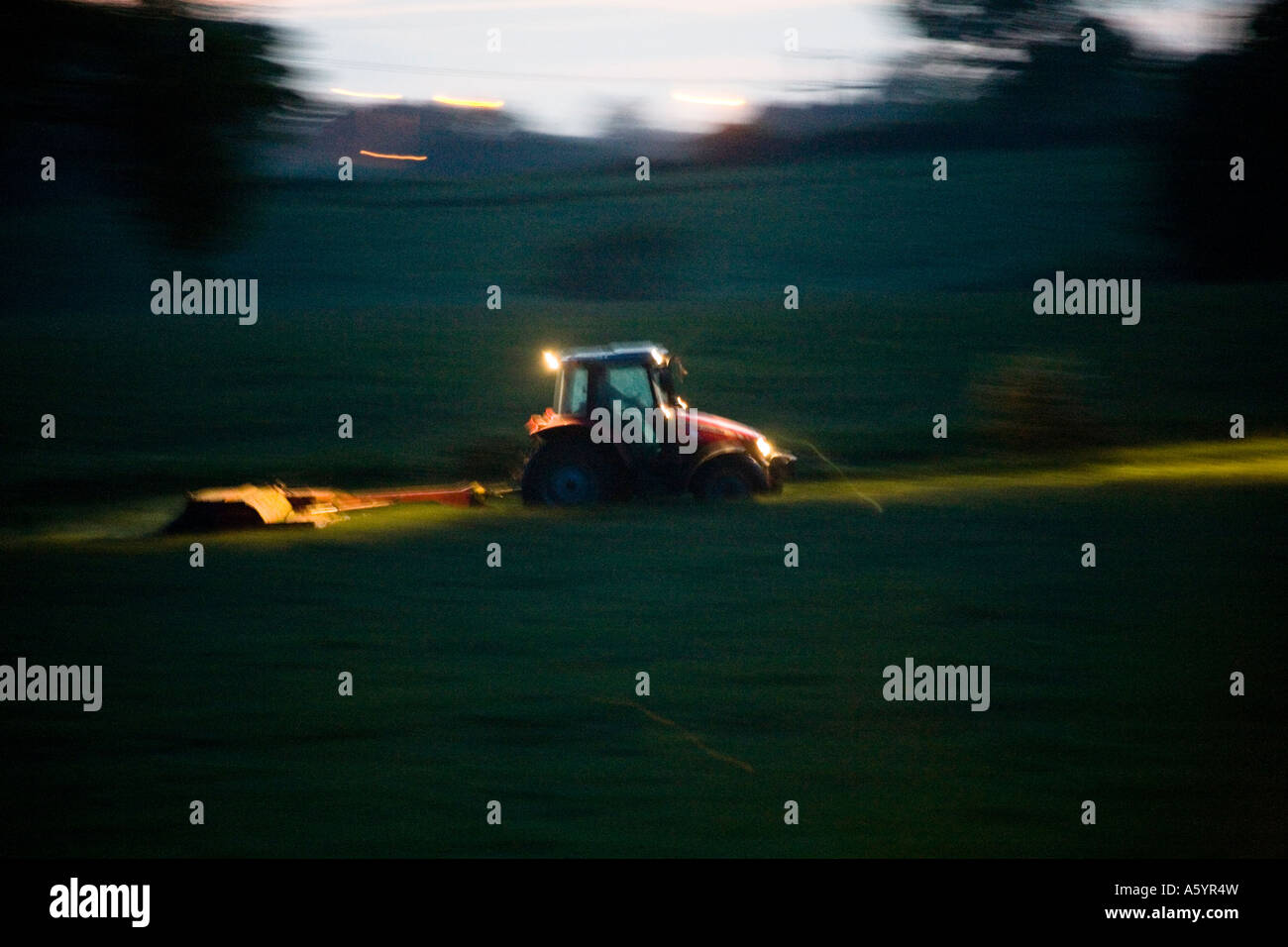 Farmworker using a tractor at night Stock Photo Alamy