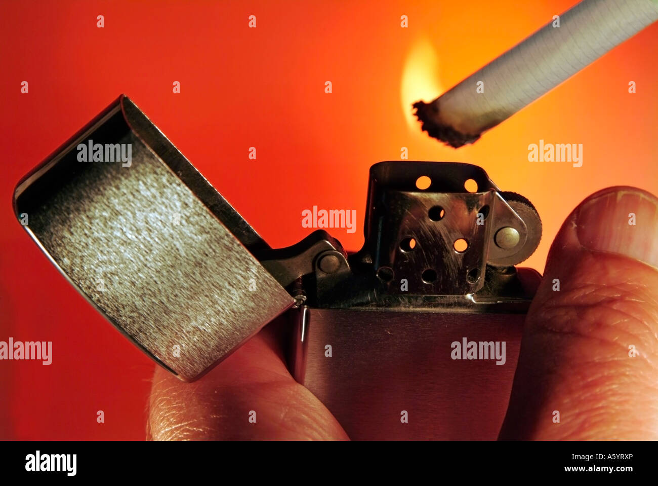 hand lighting a cigarette with a traditional cigarette pocket lighter