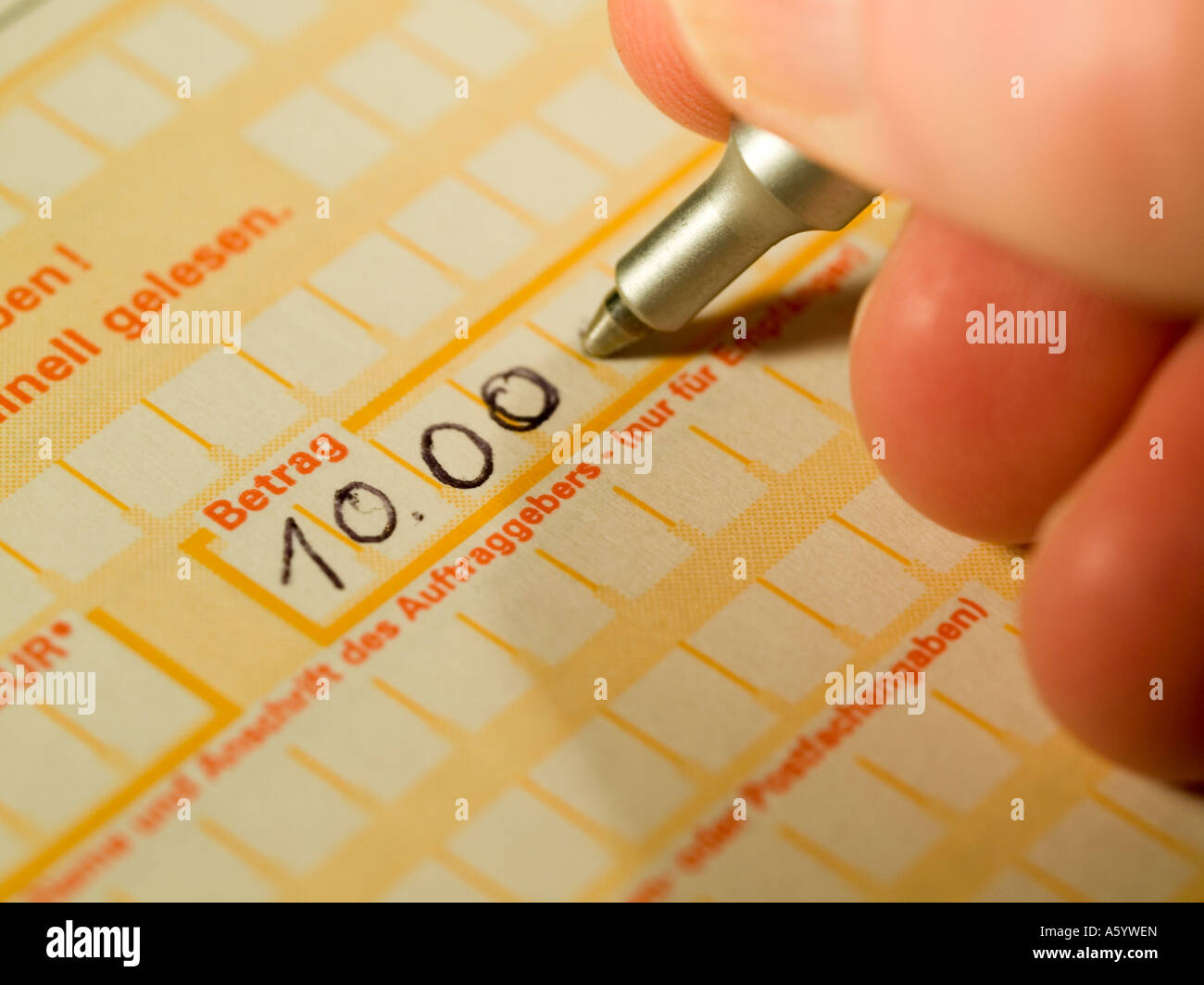 filling in a money transfer form of a german bank with a pen Stock