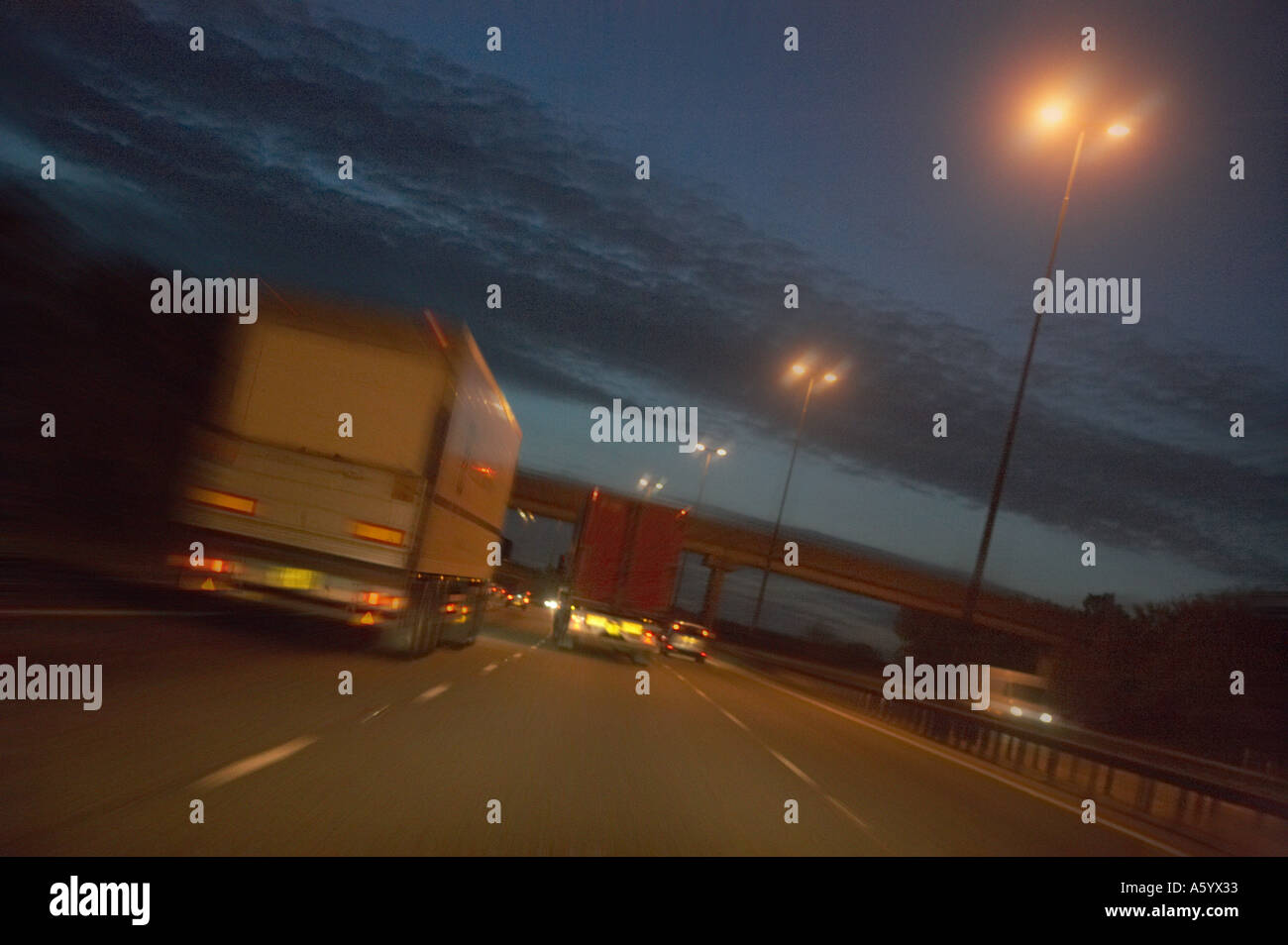 TRUCK TRAVELING AT SPEED ALONG MOTORWAY AT DUSK Stock Photo - Alamy