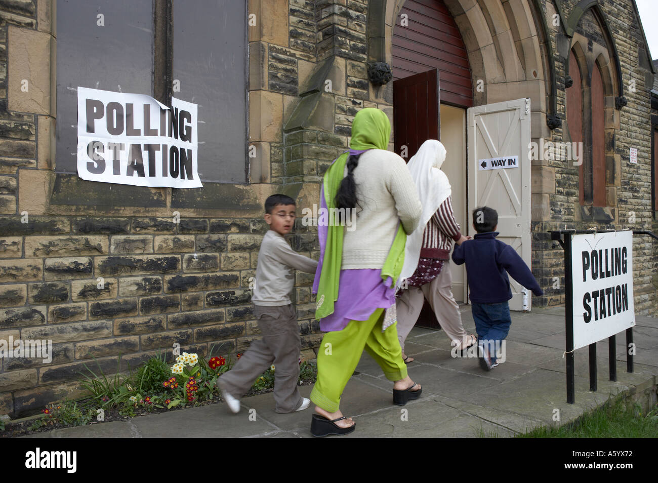 BRITISH ASIAN MUSLIMS ENTERING POLLING STATION TO VOTE IN ELECTION Stock Photo