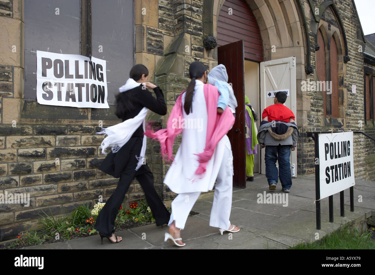 BRITISH ASIAN MUSLIMS ENTERING POLLING STATION TO VOTE IN ELECTION Stock Photo