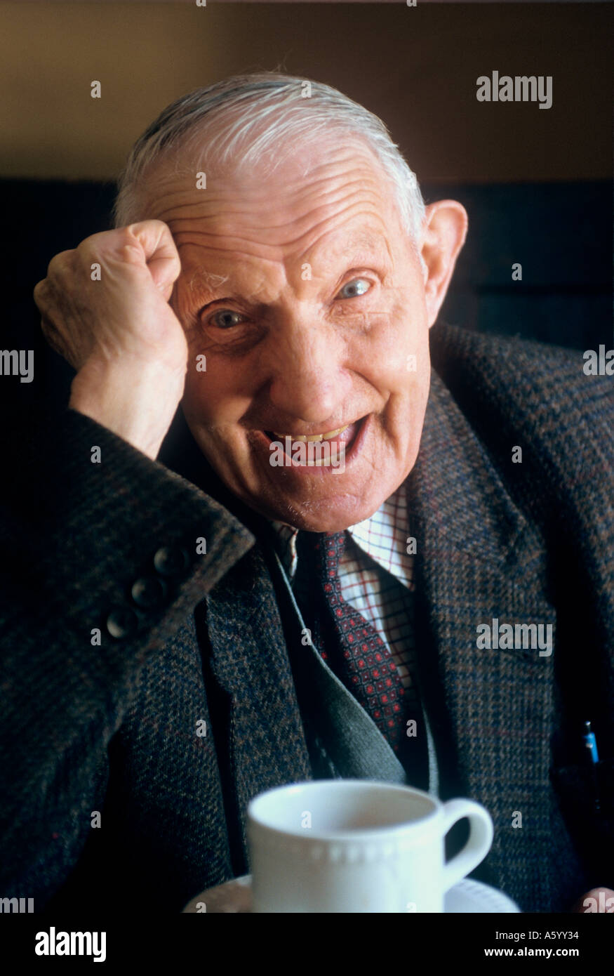 ELDERLY SENIOR MAN TEA LAUGHING LONGEVITY  Happy senior elderly man with health and vitality, at home, in natural light laughing over a cup of tea Stock Photo