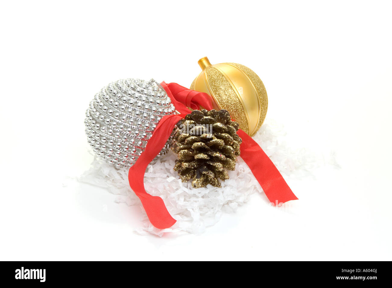 Gold and silver holiday tree ornaments with pine cone and red ribbon on ...