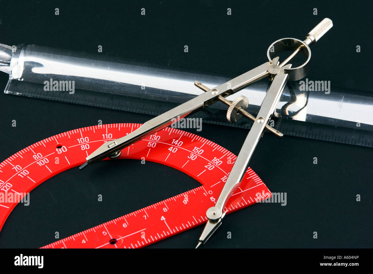 Drafting and drawing tools with compass, protractor, and scale on black