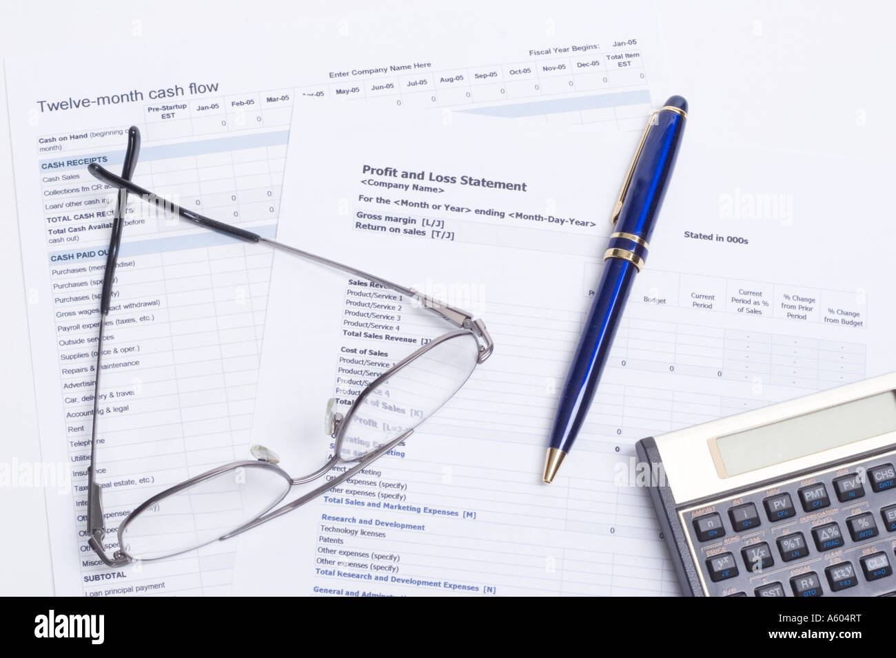 Cash Flow and Profit and Loss spreadsheets used in business for data collection and tabulation with calculator, glasses, and ink pen Stock Photo