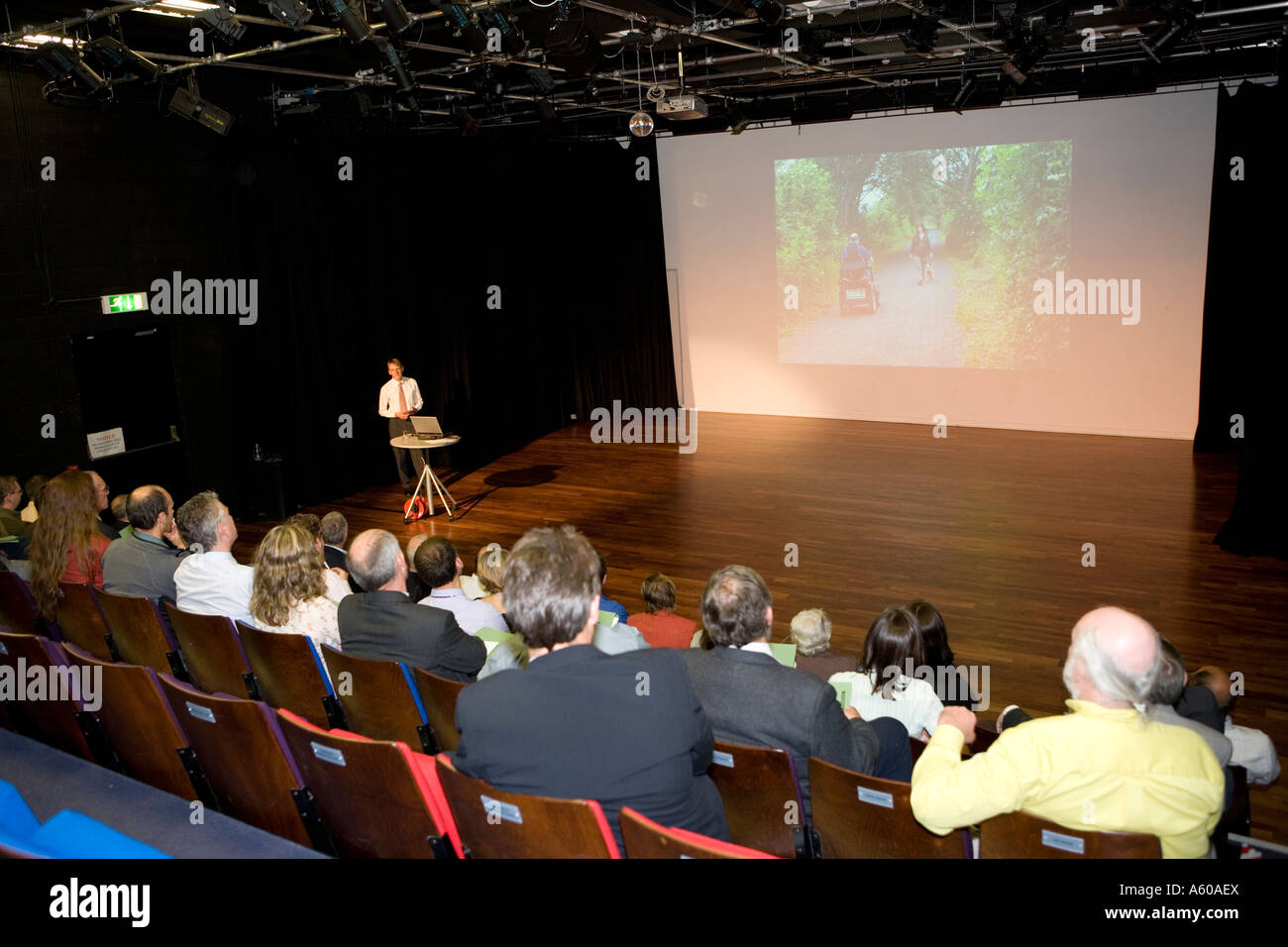 audience attending a lecture in a theatre watching a powerpoint presentation Stock Photo