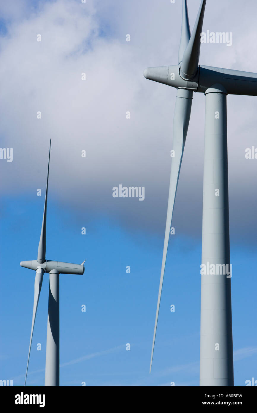 Two wind turbines againest a blue sky with clouds Stock Photo - Alamy