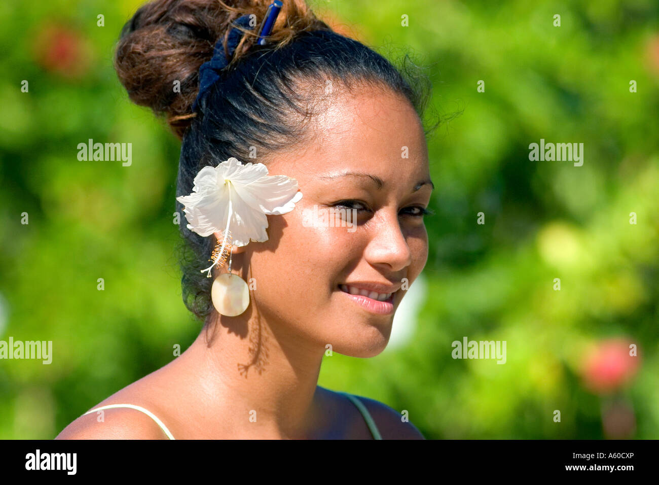 Tahitian woman wearing a tropical flower in her hair on the island of Moorea Stock Photo
