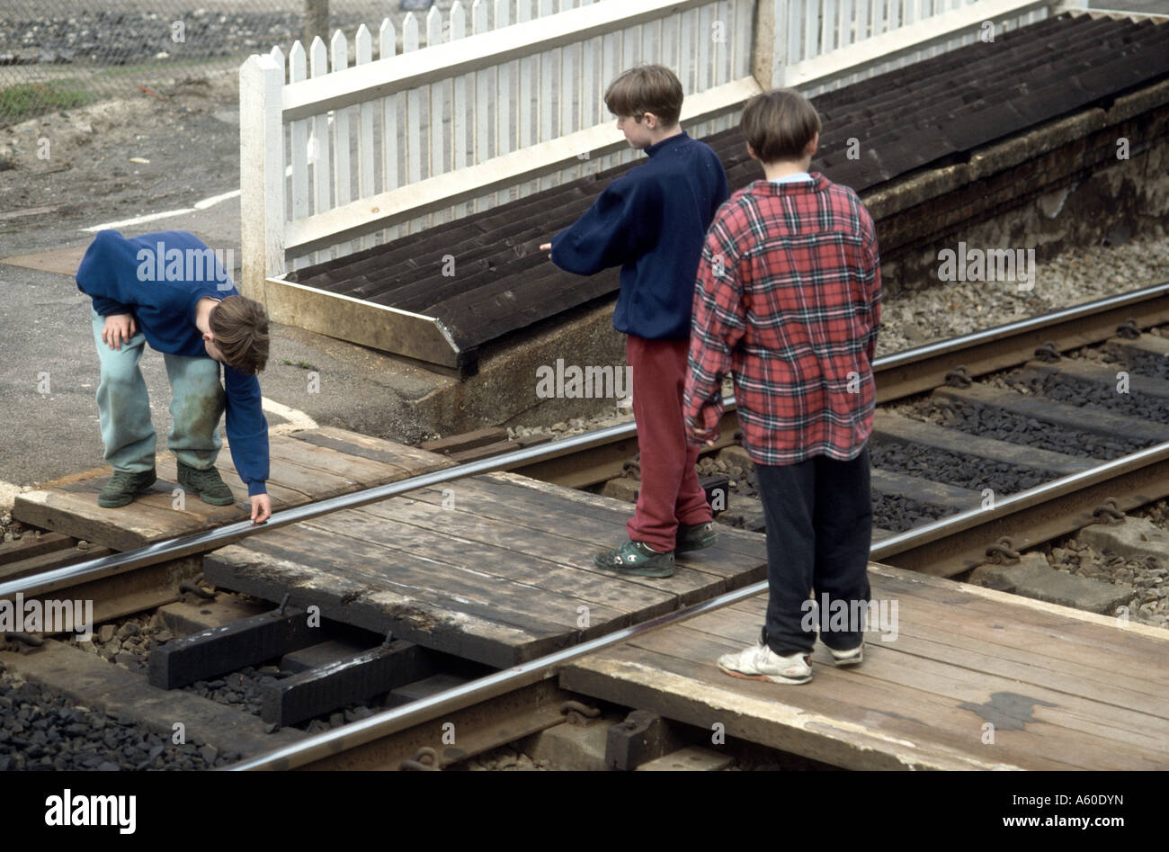 teenagers playing on train track placing coins on rail to flatten them Stock Photo Alamy