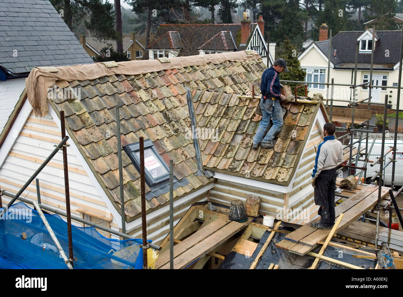 ROOFING CONTRACTORS AT WORK MAKING A NEW ROOF WITH OLD PANTILES SAFFRON
