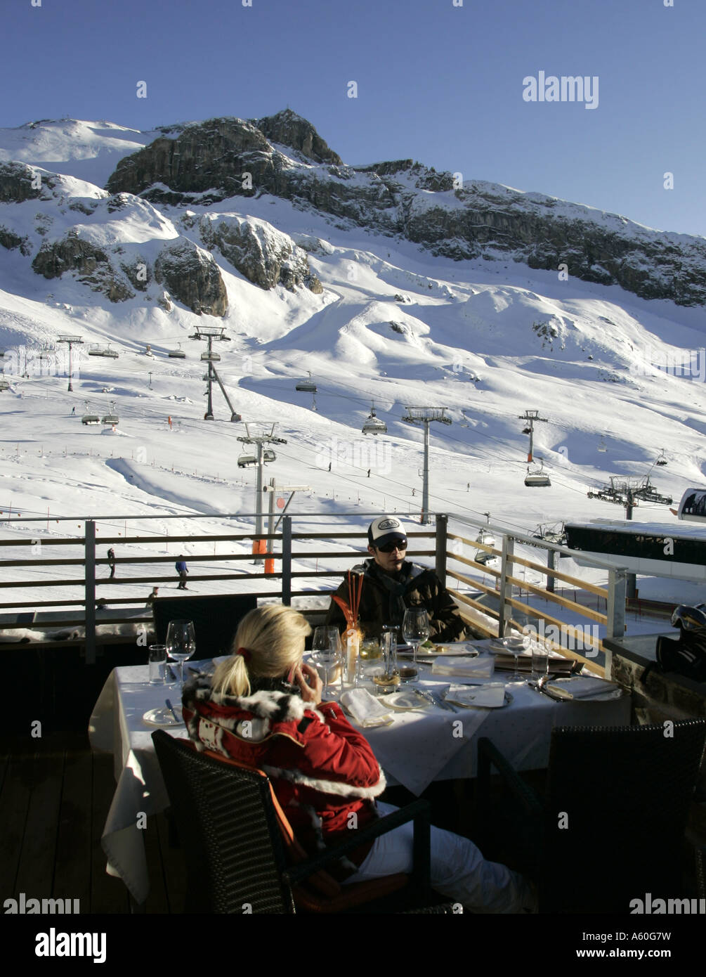 Young couple sitting on the terrace of the Alpenhaus restaurant near Ischgl in Austria Stock Photo
