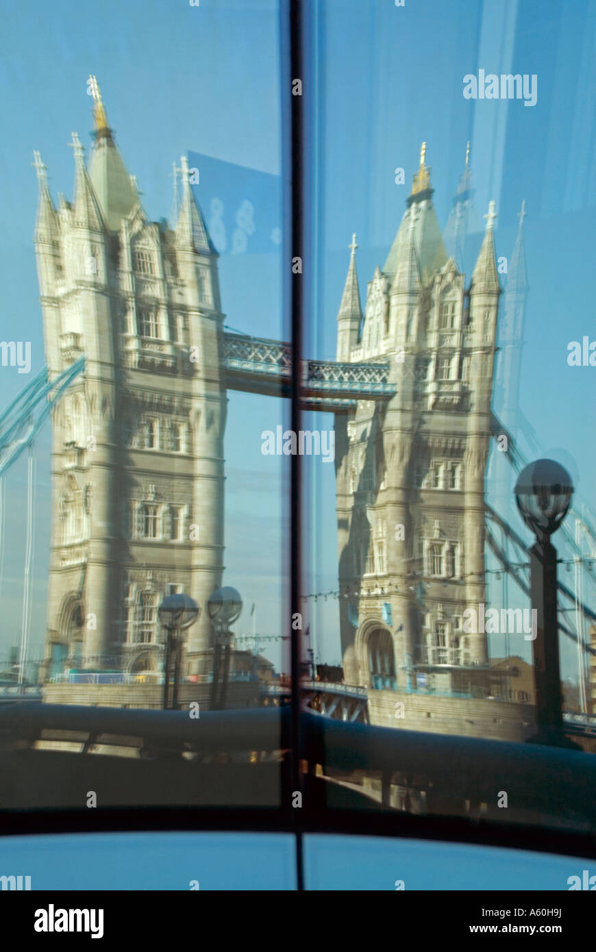 Abstract distorted vertical view of the reflection of Tower Bridge against a blue sky. Stock Photo