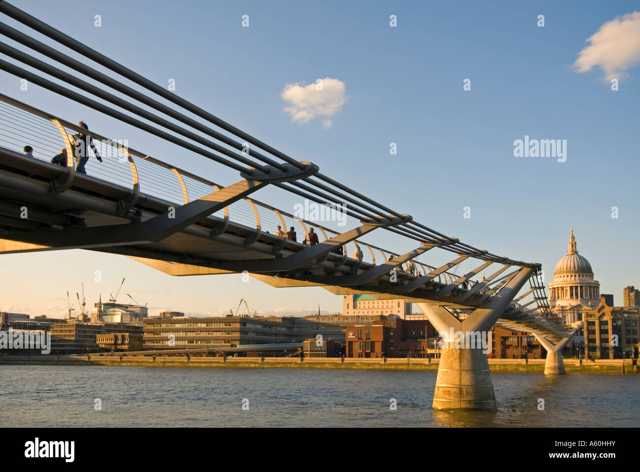Horizontal wide angle of the Millennium Bridge and St Paul's cathedral across the River Thames on a sunny evening. Stock Photo