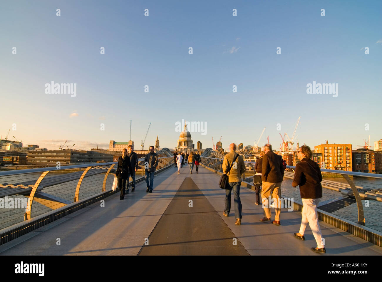 Horizontal wide angle view of the Millennium Bridge across the River Thames and St Paul's Cathedral on a sunny evening. Stock Photo