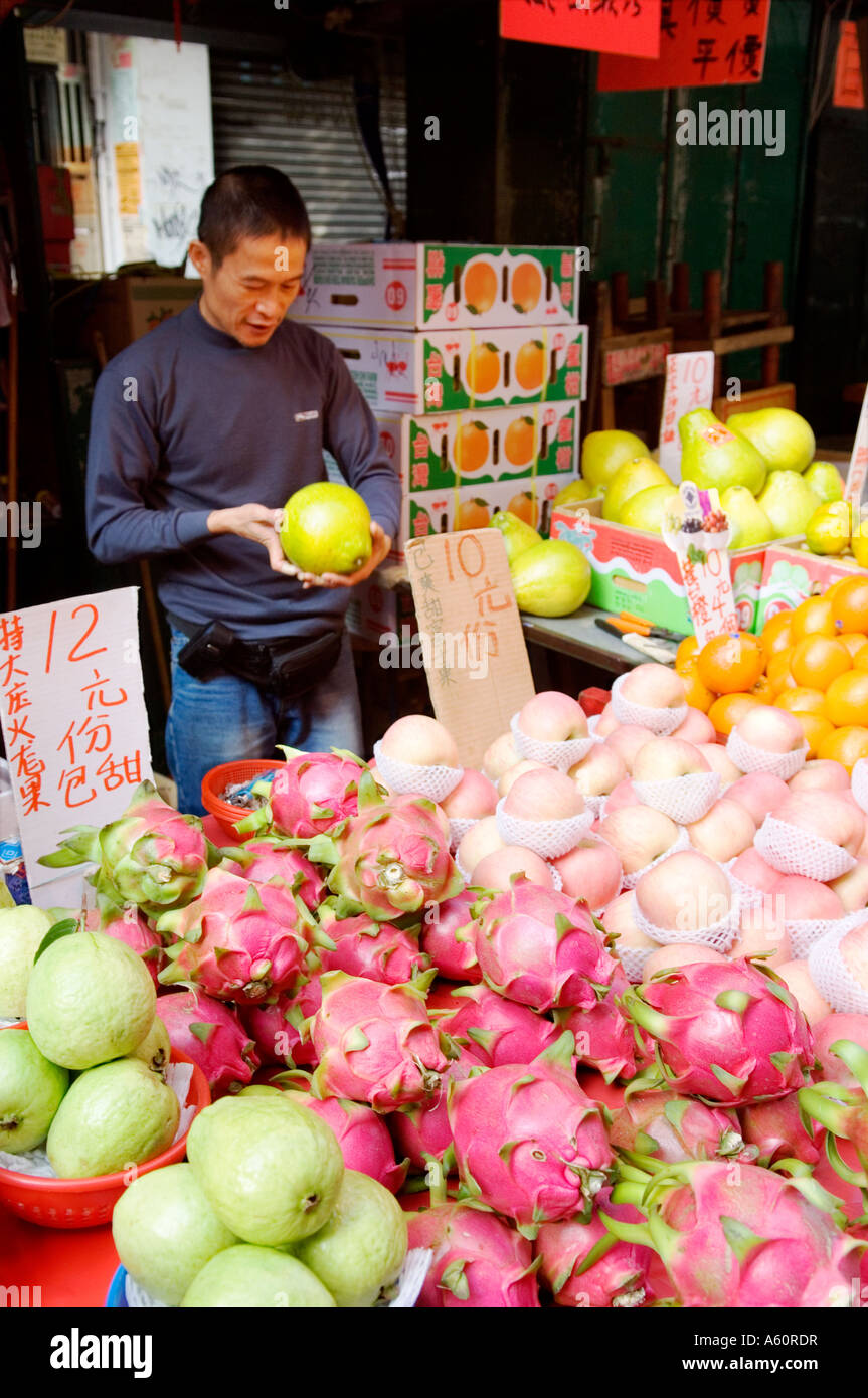 Hong Kong, China. Fruit stall vendor in Lady Market in Mong Kok area of