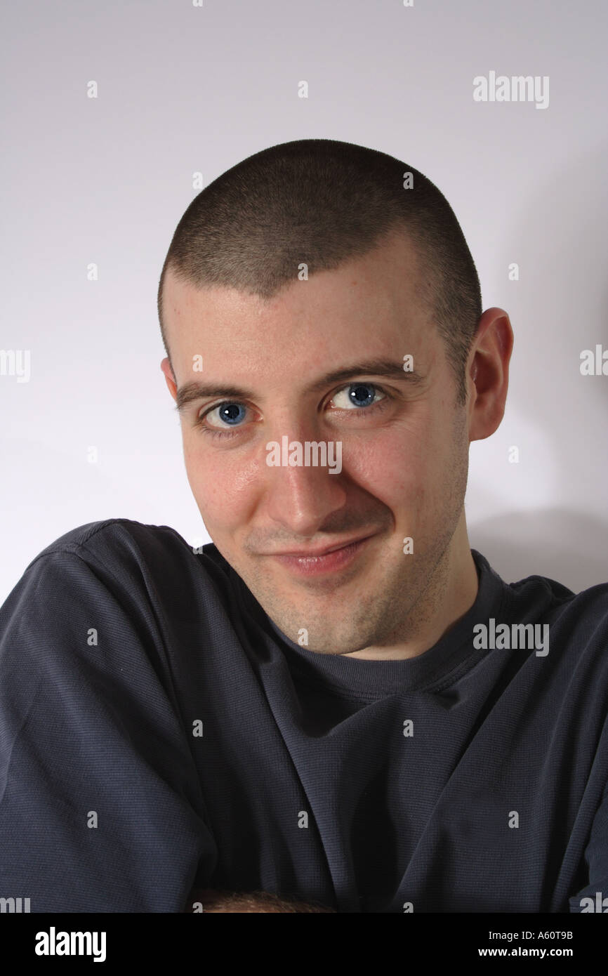 Young man in his 20s looks at the camera in a cheeky fashion Stock Photo