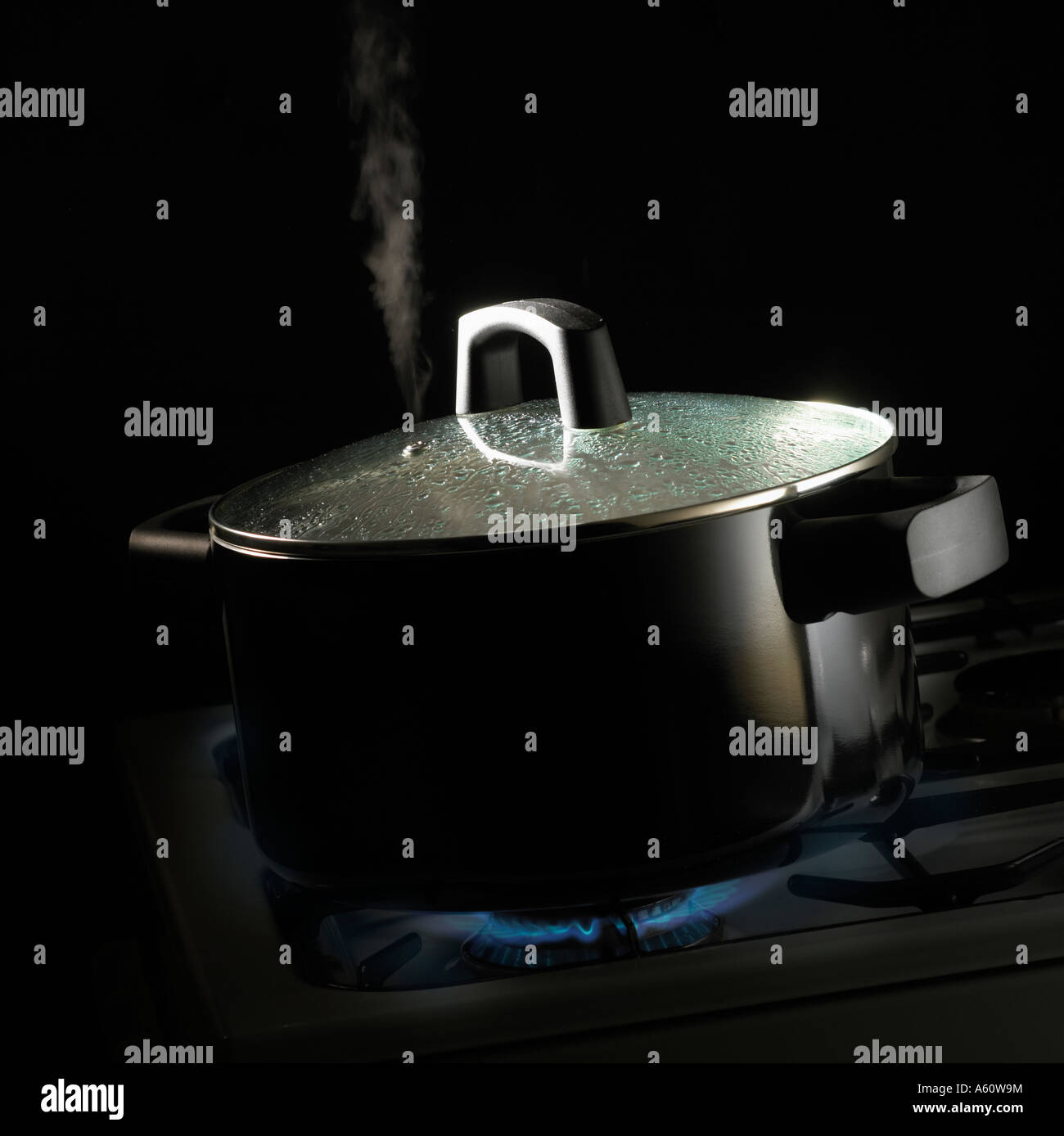 Boiling water in milk pan on gas stove Stock Photo - Alamy