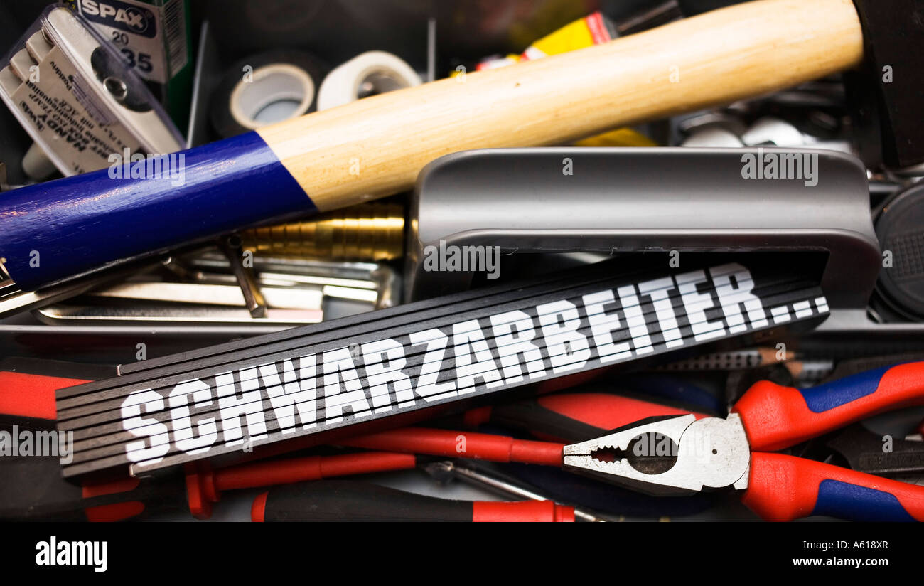 Black folding rule with writing 'schwarzarbeiter' in a tool box Stock Photo