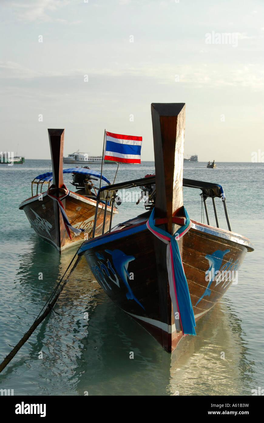 Two longtail boats with national flag Koh Lipe Thailand Stock Photo