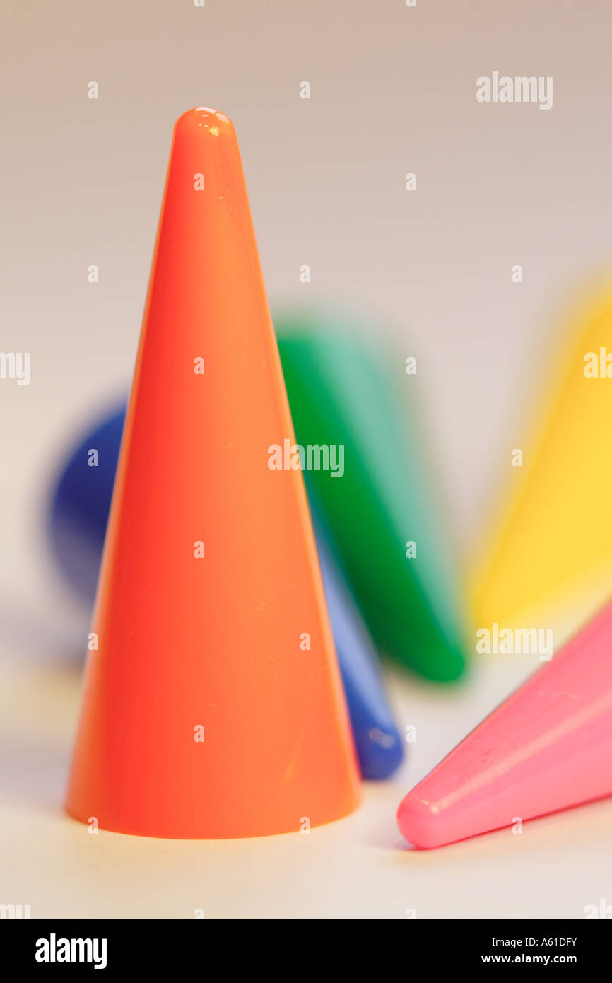 Odd one out concept orange cone standing among fallen cones Stock Photo