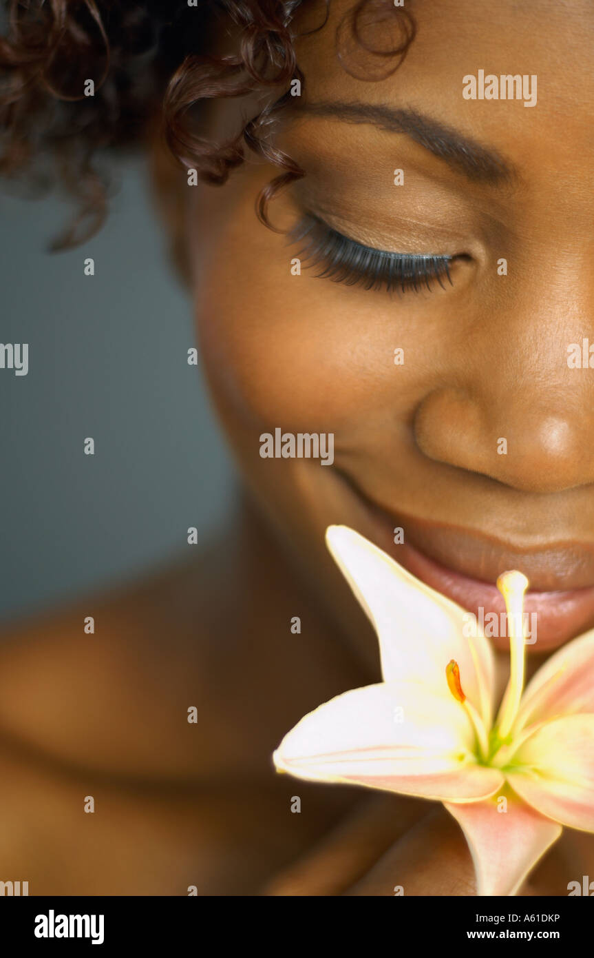 Close up of African woman smelling flower Stock Photo