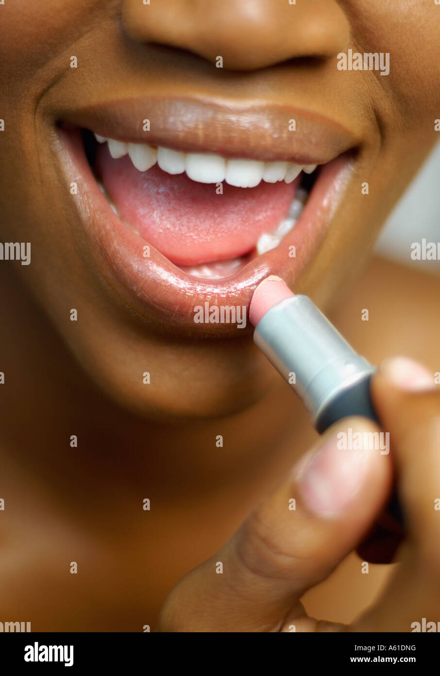 Close up of African woman applying lipstick Stock Photo