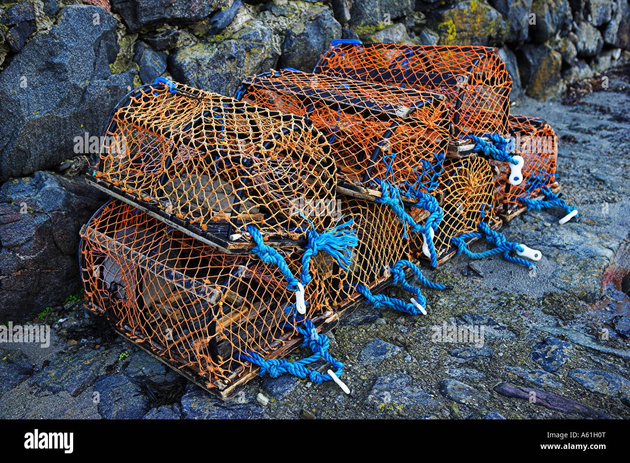 Orange and blue lobster pots stacked on the harbour side at Portsoy, North East Scotland Stock Photo