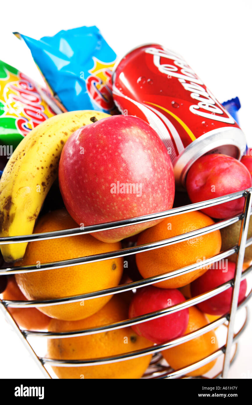 A silver fruit basket containing healthy fruit and unhealthy crisps