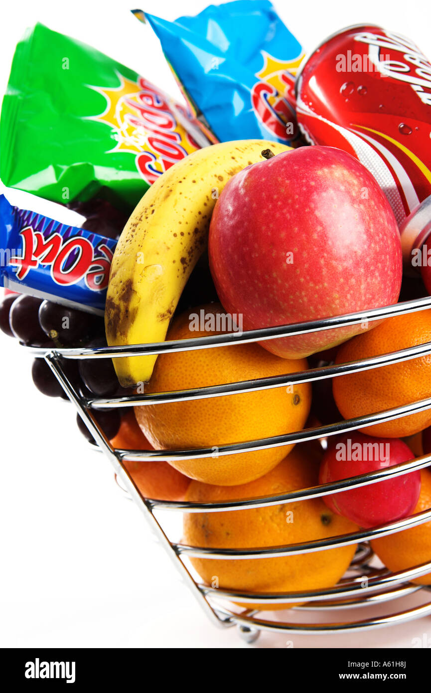 A silver fruit basket containing healthy fruit and unhealthy crisps
