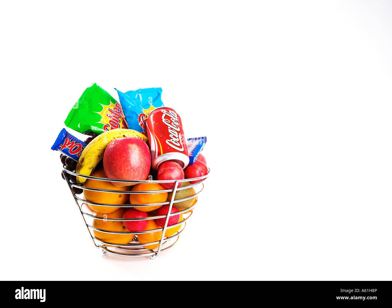 A silver fruit basket containing healthy fruit and unhealthy crisps