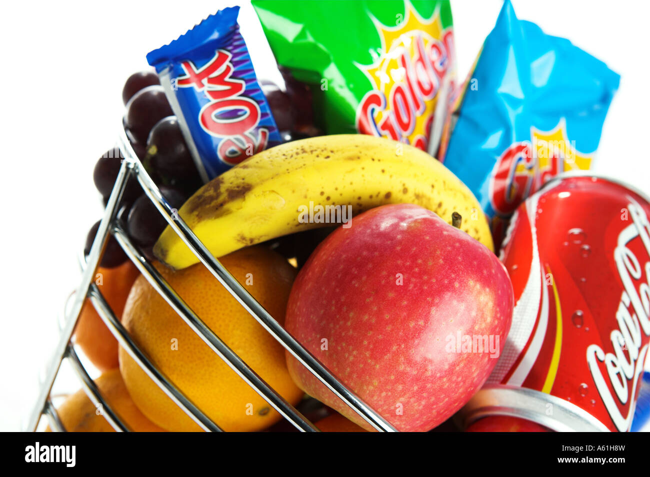 A silver fruit basket containing healthy fruit and unhealthy crisps