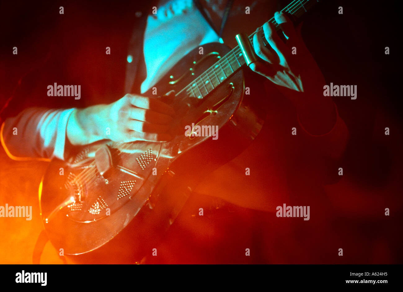 Mid section view of man playing guitar on stage Stock Photo