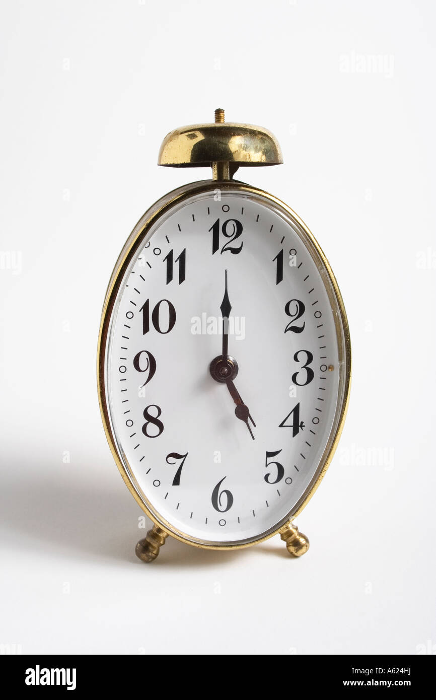 old fashion gold alarm clock 5pm numbers antique white Stock Photo Alamy
