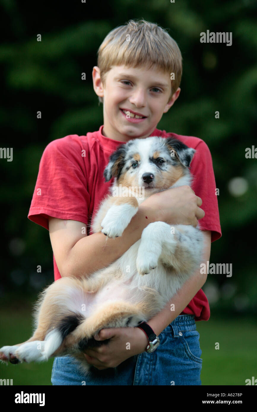 portrait of a young boy holding his puppy in his arms Stock Photo Alamy