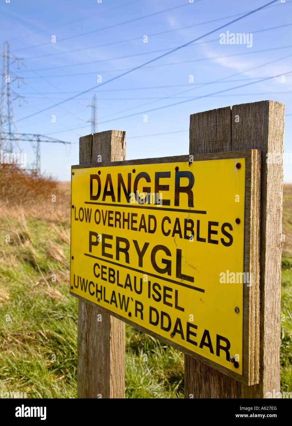 Danger low overhead cables bilingual dual language Welsh English sign Uskmouth Power Station Newport Wales UK Stock Photo