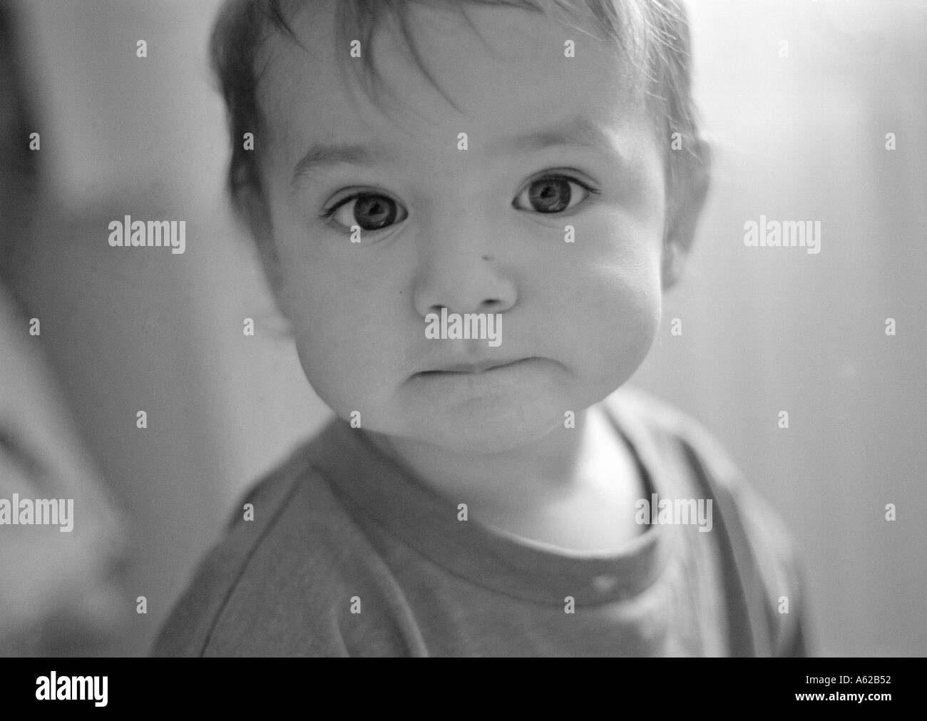 portrait of male toddler close to camera biting lip Stock Photo Alamy