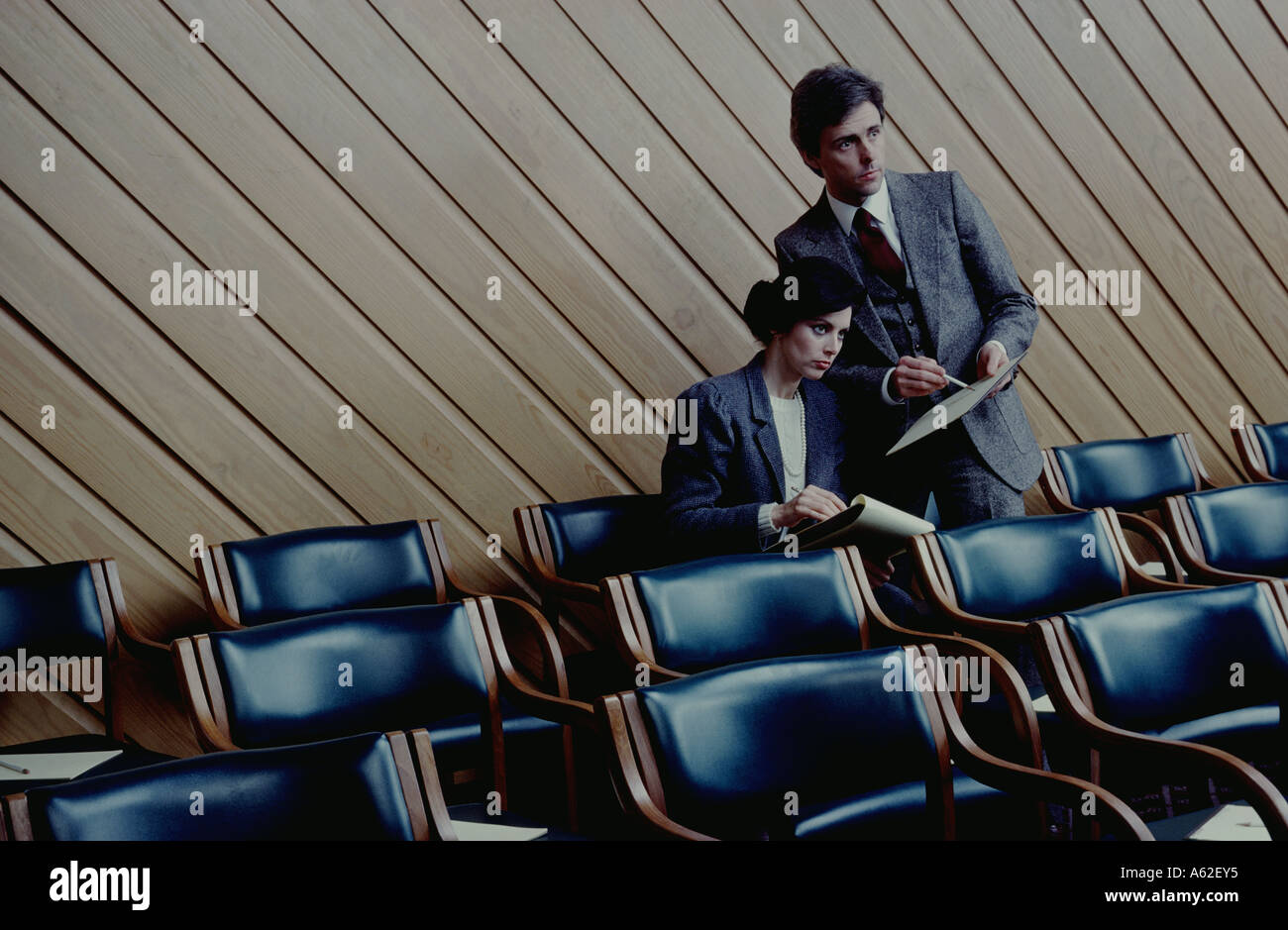 two members of a management team go over notes after an intense seminar ...